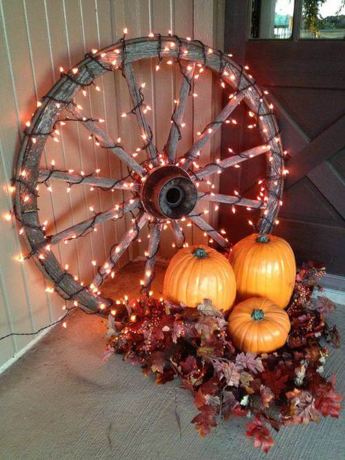 A lit up wheel of fall decor for the deck
