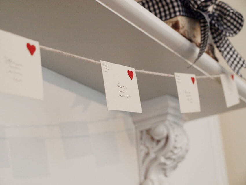 Hang love letters as garland to decorate for Valentine's Day.