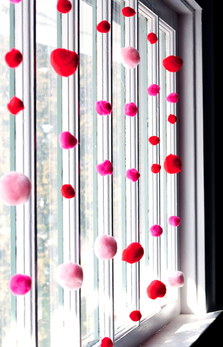 Hang red and pink pom poms in the windows for Valentine's Day.